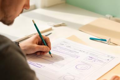 UX-disainer Tallinnas paberile selget eelarvevaadet visandamas