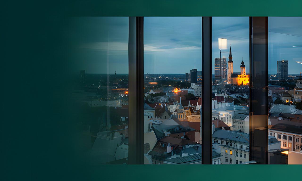 Tallinna siluett õhtuses valguses klaasise kontoriakna taga